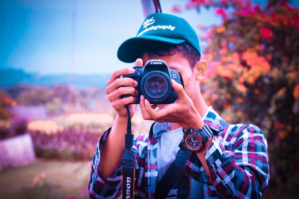 shallow focus photography of a man holding camera