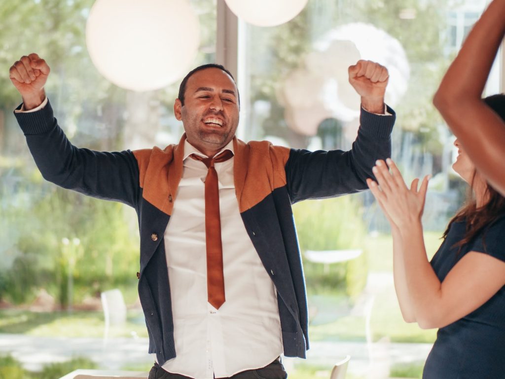 crop cheerful multiethnic colleagues celebrating victory in office